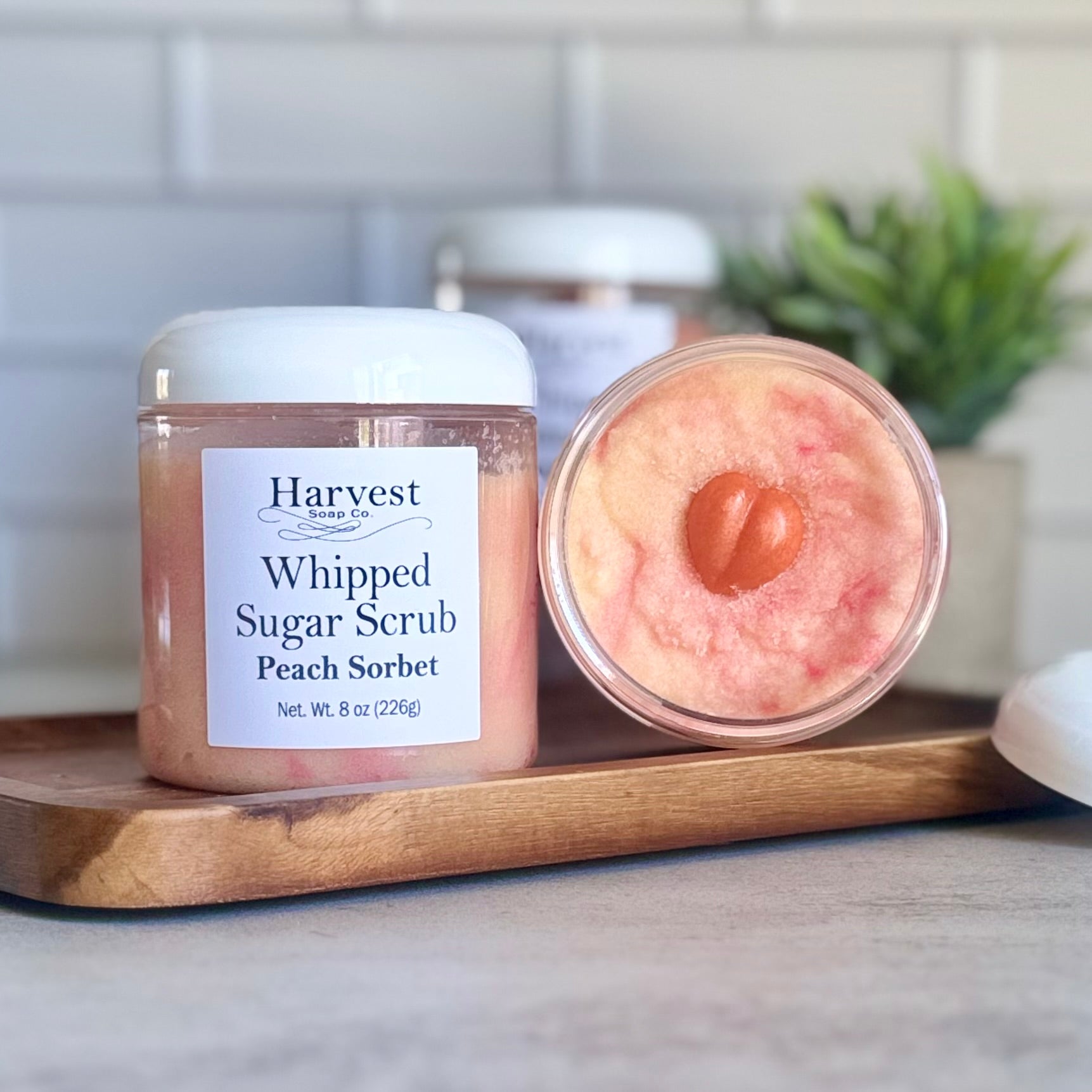 Peach sorbet whipped sugar scrub from Harvest Soap Company with peach-colored, creamy textured scrub in a jar