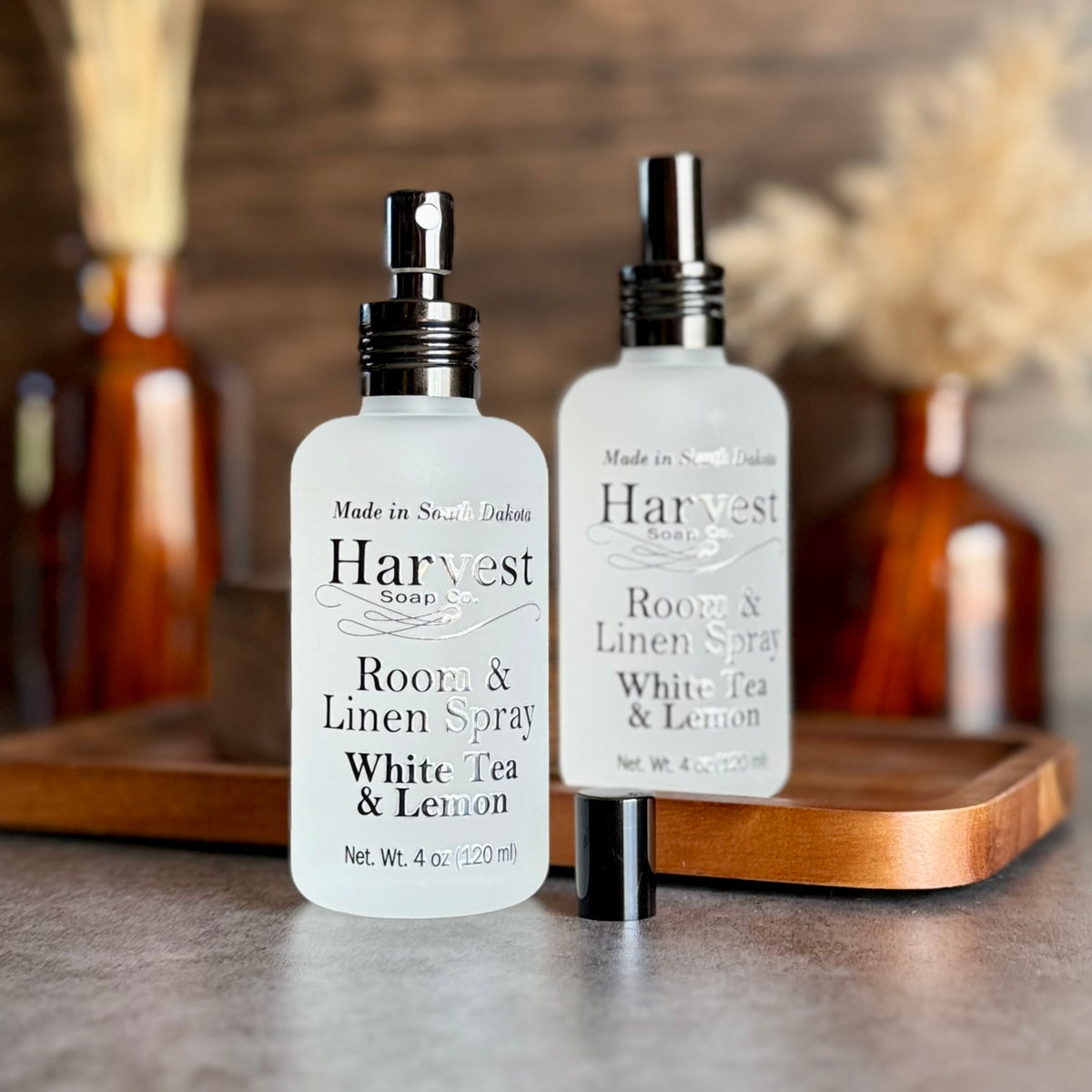 White Tea & Lemon Room & Linen Spray by Harvest Soap Company, bottle with white label and spray nozzle on a neutral background.