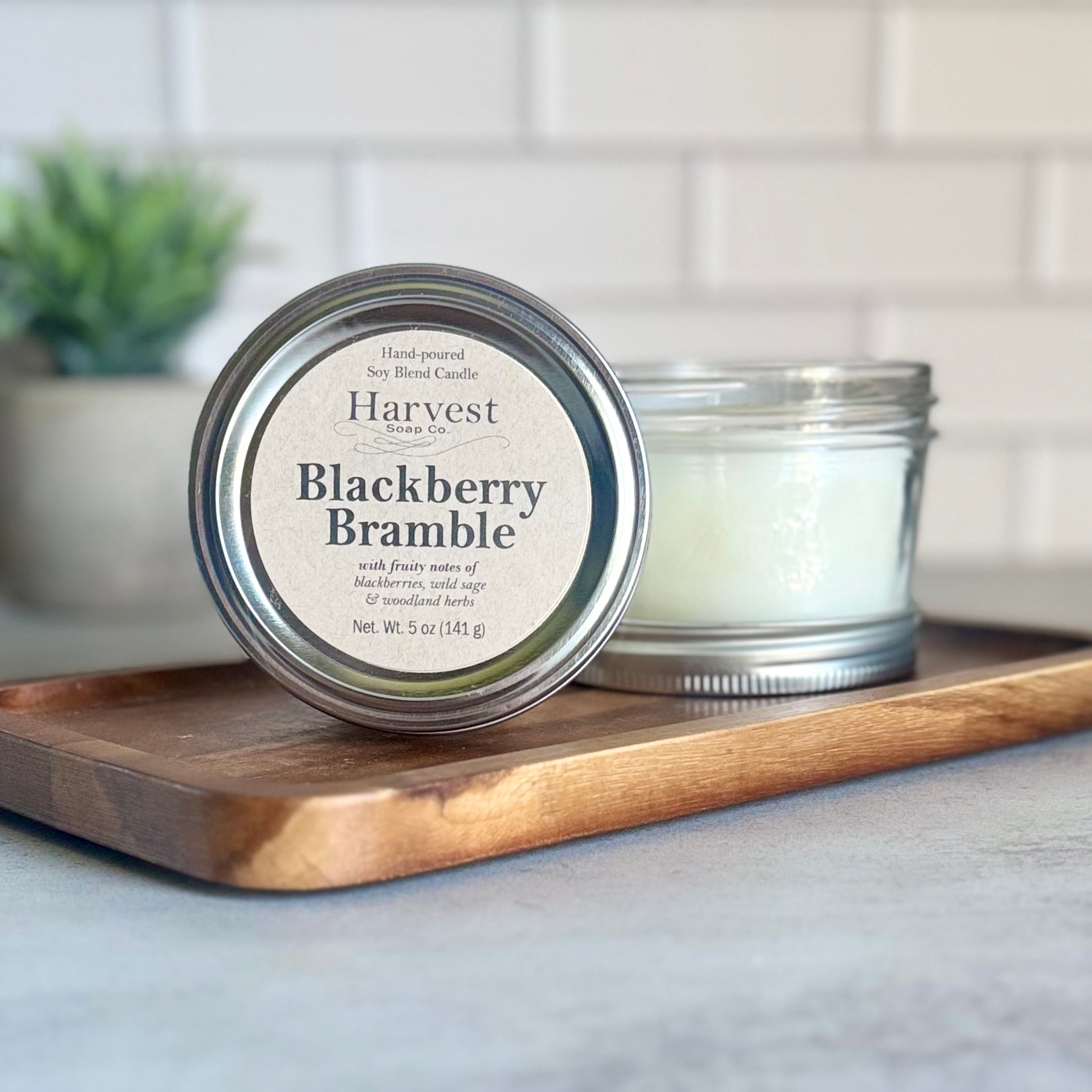 Blackberry Bramble Candle by Harvest Soap Company featuring a glass jar with a flickering wick and blackberry-themed label.